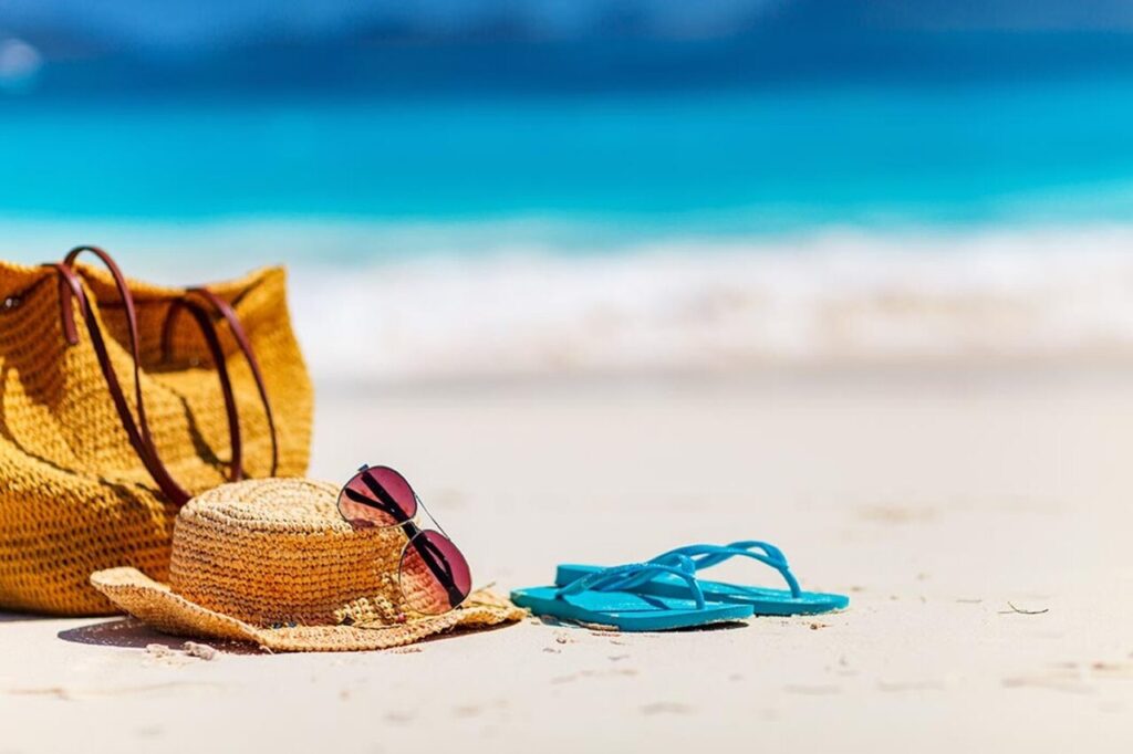 Imagem de uma praia com acessórios de um funcionário que pediu adiantamento das férias na areia - Foto: Freepik