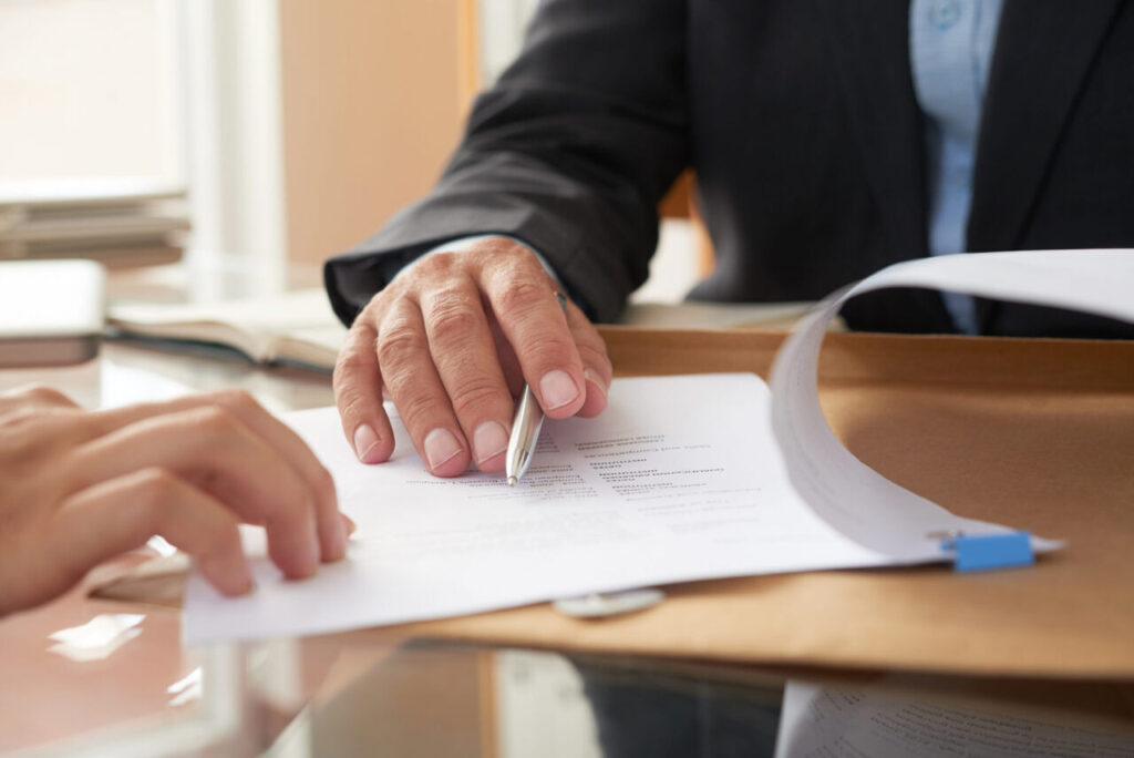 Pessoa mostrando um contrato de trabalho por prazo determinado para outra pessoa - Foto: Freepik