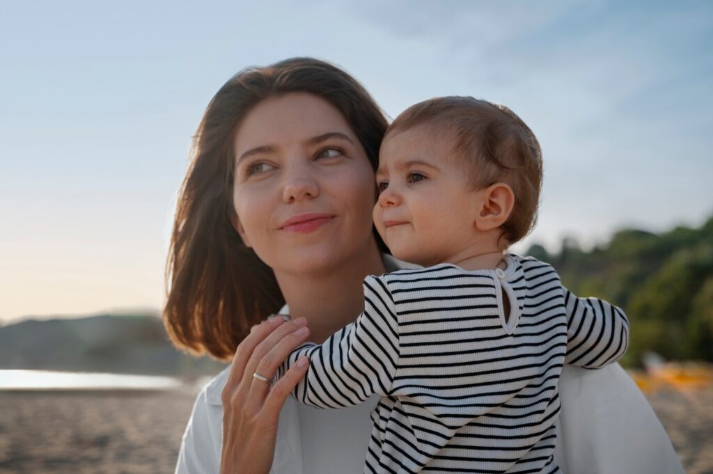 Mãe segurando o filho no colo - Freepik