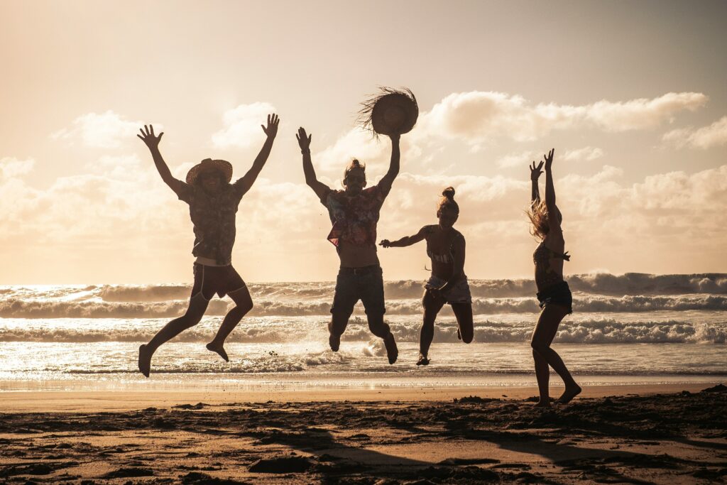 Pessoas se divertindo em uma praia - Foto: Unsplash