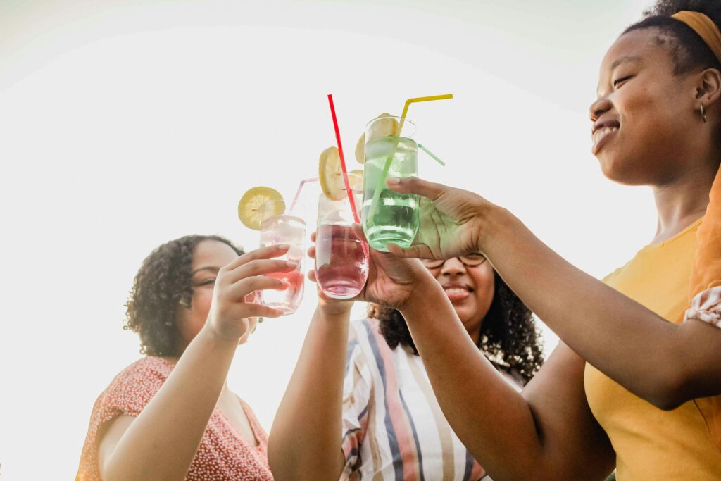 Pessoas brindando com copos de bebida - Foto: Unsplash