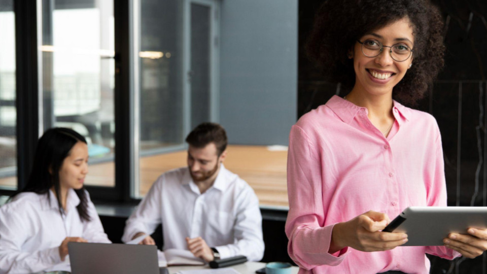 Esta última imagem retrata um ambiente de trabalho colaborativo, positivo e tecnologicamente integrado. Ela serve como um contraponto ideal às imagens de estresse, mostrando o resultado de uma boa gestão e de ferramentas eficientes.