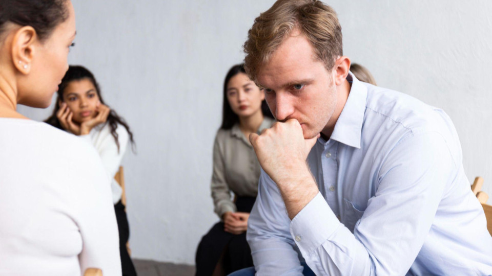 A imagem mostra uma situação de conversa ou apoio emocional em grupo.