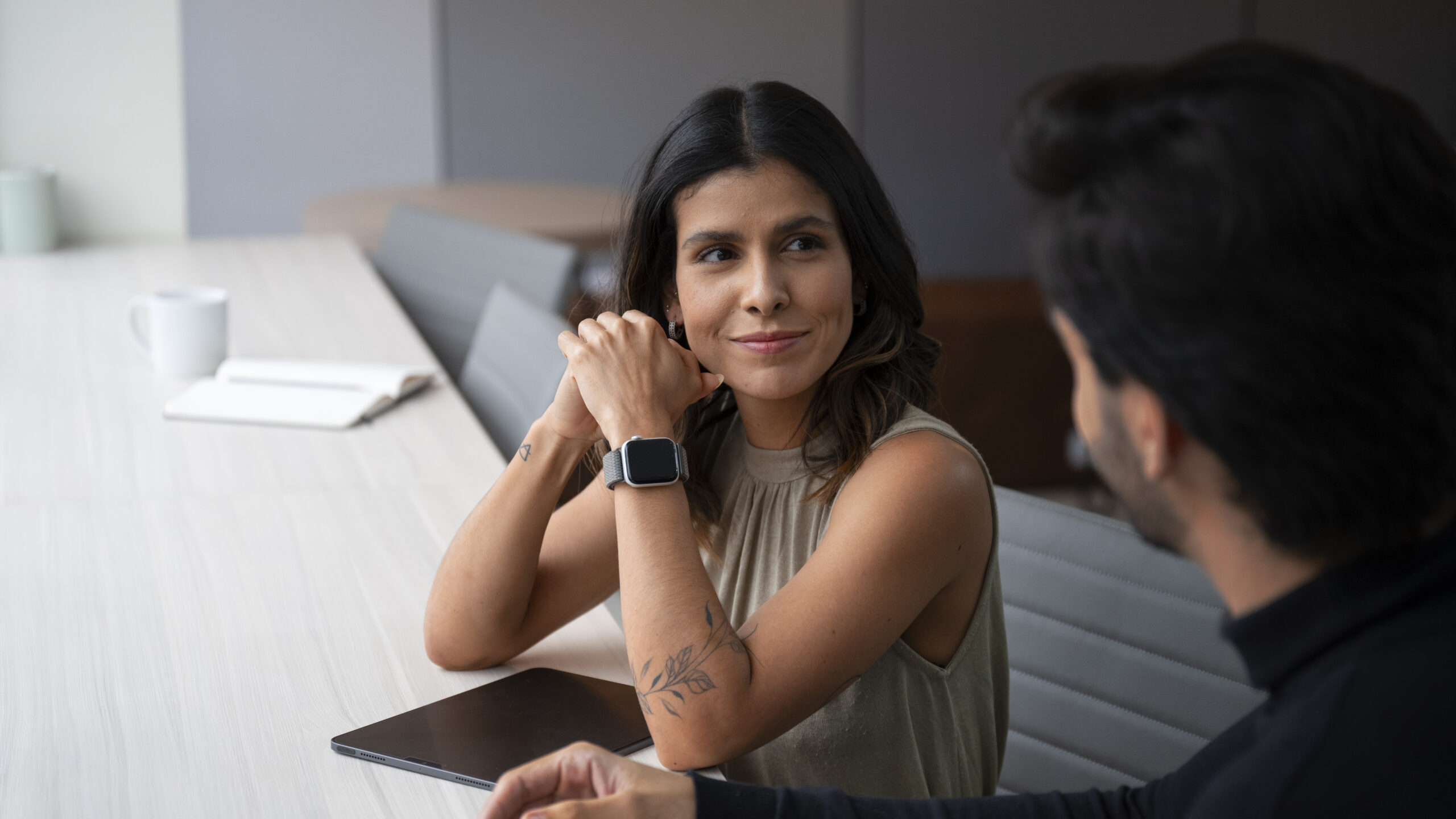 A imagem retrata um encontro profissional em ambiente corporativo moderno e acolhedor.