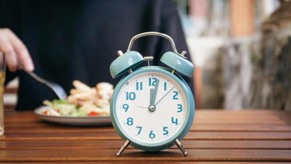 O relógio de ponteiro azul claro indica exatamente 12 horas e 5 minutos (ou 12:05).