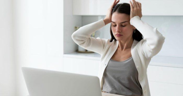 Esta imagem retrata uma cena comum de estresse, cansaço ou sobrecarga mental no ambiente de trabalho.
