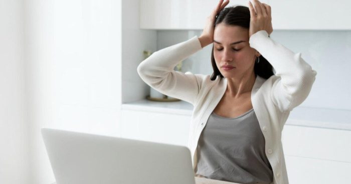 Esta imagem retrata uma cena comum de estresse, cansaço ou sobrecarga mental no ambiente de trabalho.