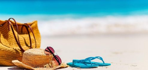 Imagem de uma praia com acessórios de um funcionário que pediu adiantamento das férias na areia - Foto: Freepik