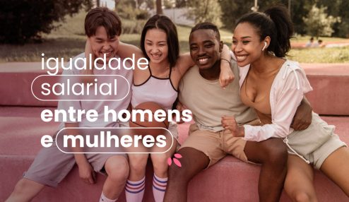 Quatro pessoas abraçadas em um parque. Elas estão sentadas e se apertando umas contra as outras. No título da imagem 'igualdade salarial entre homens e mulheres'.