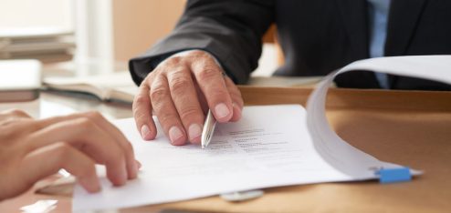 Pessoa mostrando um contrato de trabalho por prazo determinado para outra pessoa - Foto: Freepik