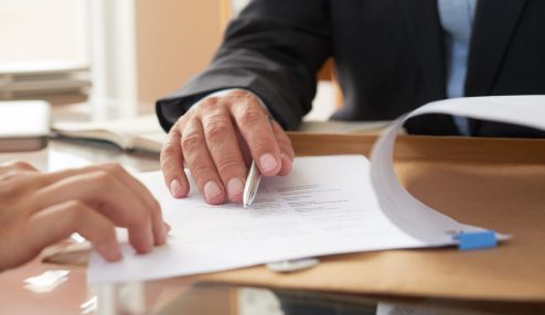 Pessoa mostrando um contrato de trabalho por prazo determinado para outra pessoa - Foto: Freepik