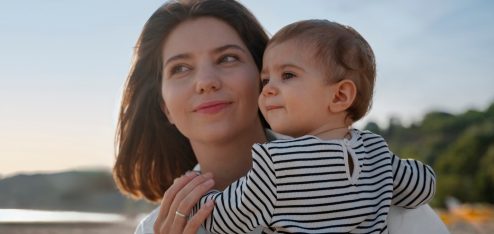 Mãe segurando o filho no colo - Freepik