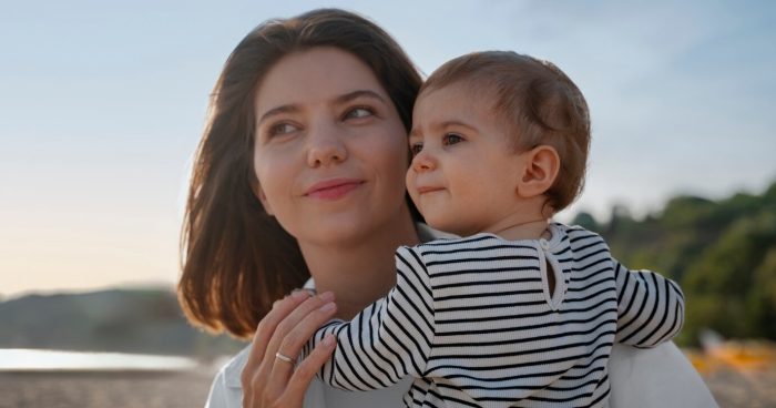 Mãe segurando o filho no colo - Freepik