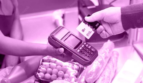 A imagem mostra as mãos de duas pessoas: uma caixa de supermercados segurando uma máquina de cartões e um cliente aproximando o cartão Eva da máquina.