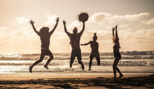 Pessoas se divertindo em uma praia - Foto: Unsplash