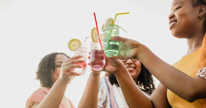Pessoas brindando com copos de bebida - Foto: Unsplash